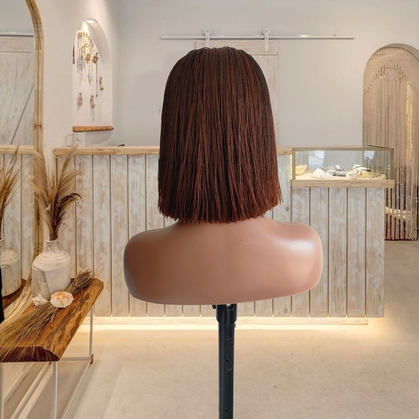 Mannequin head with a brown bob wig in a stylish interior setting