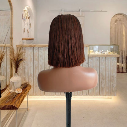 Mannequin head with a brown bob wig in a stylish interior setting