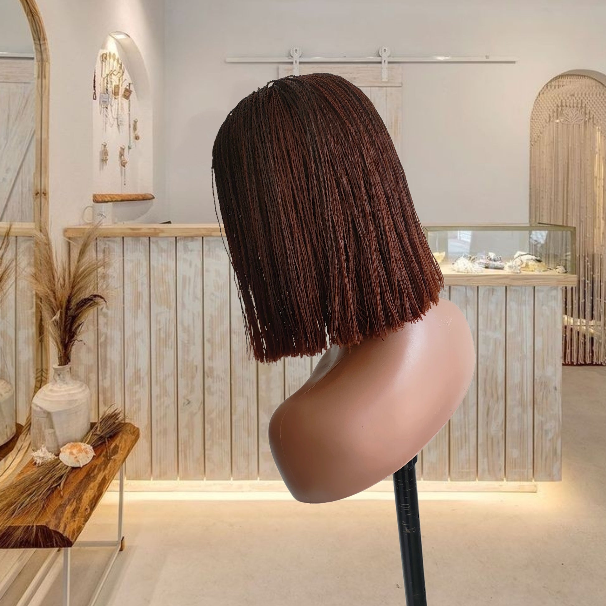 Mannequin head with a brown bob wig in a stylish interior setting