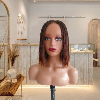 Mannequin head with a brown wig in a decorative room.